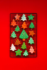 Beautiful bright cookies in the form of Christmas trees prepared for the holiday of Christmas and New year. Background, top view, Holiday cookies on a red background.