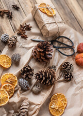 Fototapeta na wymiar Geschenke zu Weihnachten natürlich verpacken mit Orangenscheiben und Zapfen