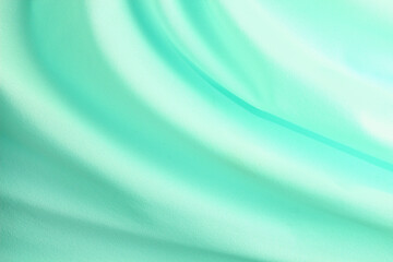 turquoise material flows in soft folds background