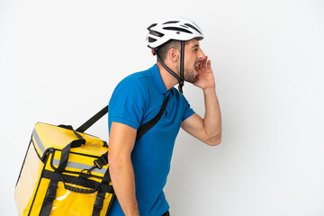Young caucasian man with thermal backpack isolated on white background shouting with mouth wide open to the side
