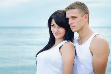 Fototapeta premium guy and a girl in jeans and white t-shirts on the beach
