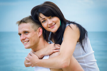 Fototapeta premium guy and a girl in jeans and white t-shirts on the beach