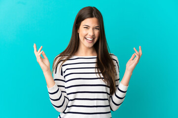 Teenager Brazilian girl over isolated blue background smiling a lot