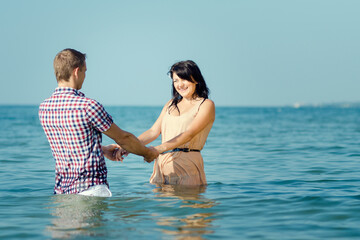 a guy and a girl walk along the seashore