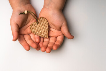A heart made of eco-friendly materials in the hands of a child. Caring for the environment, mothers Day, concept