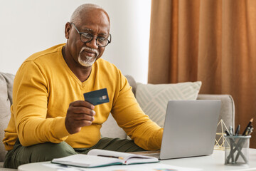 Senior African Man Shopping Using Credit Card And Laptop Indoor