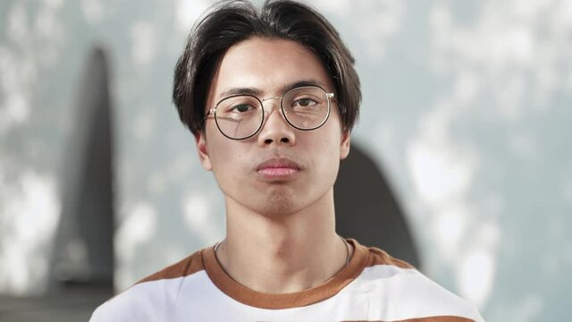 Portrait Of Calm Young Asian Teenager Guy Wearing Glasses And Looking Serious Confident At Camera