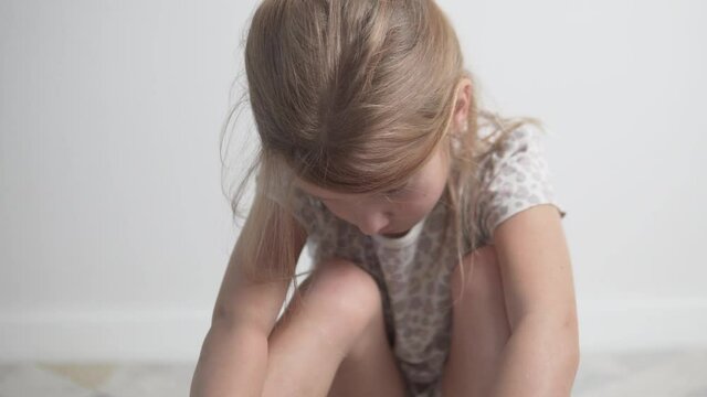 Close-up, a resentful little girl cries at home.