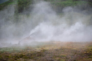 Fototapeta na wymiar Landscape of steam coming off of Geysir Golden Circle Iceland