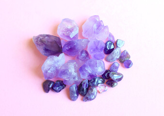 Minerals of gemstones on a pink background. Beautiful purple crystals of amethyst.
