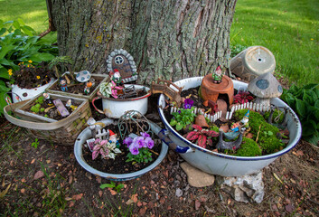 A small gnome village built beside a silver maple tree.