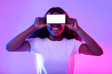 Smartphone screen mockup. Black woman covering eyes with empty phone, offering space for mobile app in neon light