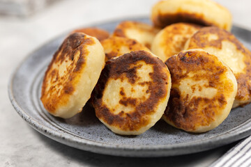 Plate of delicious cottage cheese pancakes, homemade curd fritters, closeup