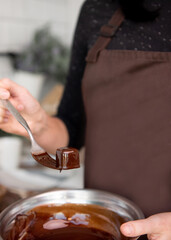 person in the kitchen with chocolate candy. Copy space. Close-up. 