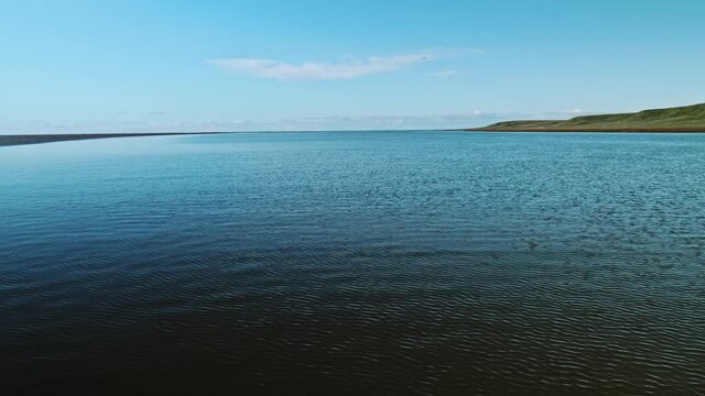 Landswell line of Kara sea in sunny afternoon on Yamal peninsula. Bright blue sky over the water
