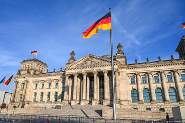 Fototapeta na wymiar Bundestag, Berlin. German national flag flying on a flagpole in a front of Reichstag Building in Berlin, Germany. State and national symbol. 