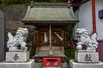 A traditional Japanese shrine with a statue of two lions dogs