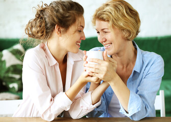 lifestyle and people concept: Senior Woman With Adult Daughter Relaxing On Sofa At Home