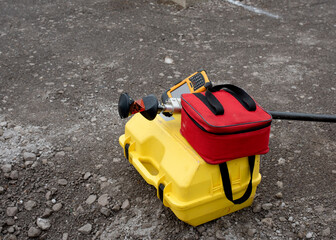 Pogo with prism and controller on top of box with robotic total station, and red soft bag for prism and controller transportation when not in use. left on the grond by site engineer