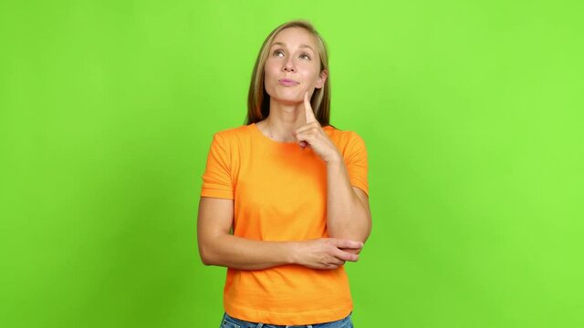 Young blonde girl standing and thinking an idea pointing the finger up over isolated background. Green screen chroma key