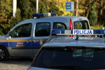Radiowóz polskiej policji na sygnałach alarmowo przez miasto.