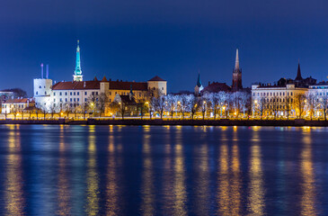 Night view to the historical city center with castle and churches  from the banks of Daugava river...