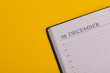 Notepad or diary with the exact date on a yellow background. Calendar for December 6 - winter time. Space for text.