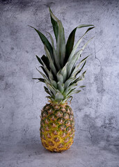 close up of ripe pineapple on a grey  background 