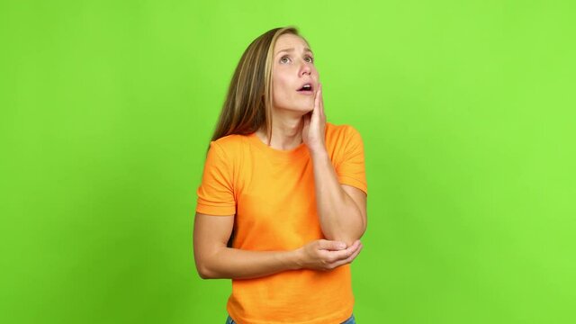 Young blonde girl gaping because have just surprised with a gift over isolated background. Green screen chroma key