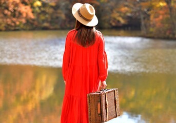 旅行の女性・紅葉の湖畔を楽しむ