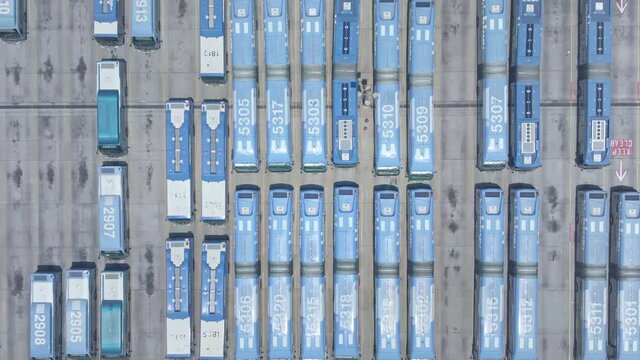 Aerial drone view. City buses in bus terminal depot in Los Angeles.  Transfer station, commuter life in American city.  