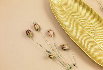 Dry red poppy flowers on beige background. Bouquet of dried flowers and empty golden tray. Floral minimalistic background. Mockup
