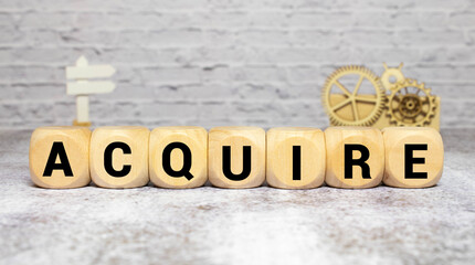 word Acquire on wooden block, business concept