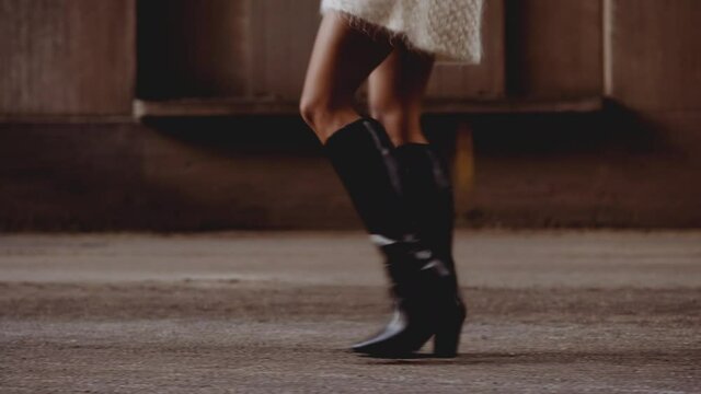 Woman In Woollen Dress And Boots With Windswept Afro Hair Walking