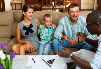 Happy family with preteen boy meeting financial adviser for investment at home