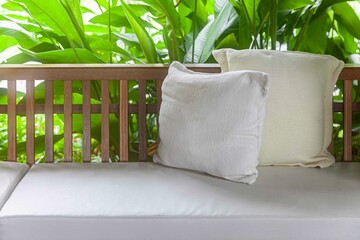 Empty brown wooden sofa and cushions with cream cotton cushions in the home garden