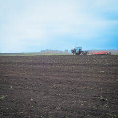 Fototapeta premium In the field, work is underway on plowing the land with tractors.