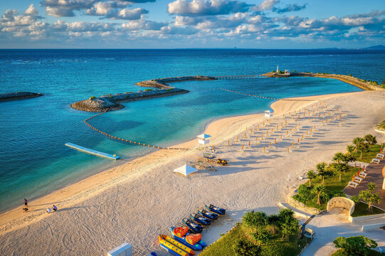 Aerial view of a beach, lagoon, small islands and bridges and a distant lighthouse in Okinawa, Japan, Onna Son district, just before sunset