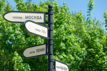 Plates on a post with an inscription in Russian: Moscow, Rome, Beijing, New York.