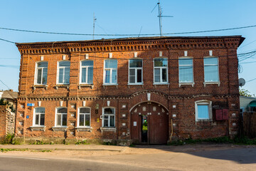 Fototapeta na wymiar Old two-story brick residential building on Uritskogo street in the city of Borovsk, Russia - June 2021