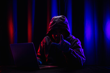 Hackers wear hoods to cover their faces. Hacking to steal important information. Use a computer to...