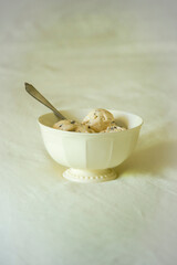 White bowl with ice cream on white linen