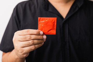 The young man showing the condom into camera. Campaign for safe sex and contraception. Close up...