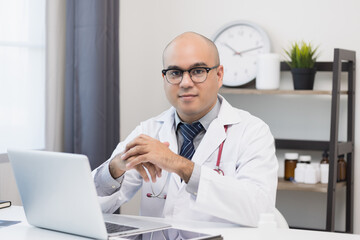 Doctor talks to patient via online video conferencing with computer laptop wearing headset. Explain about taking medications to treat illnesses.