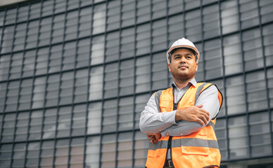 Asian engineer handsome man or architect looking forward with white safety helmet in construction...