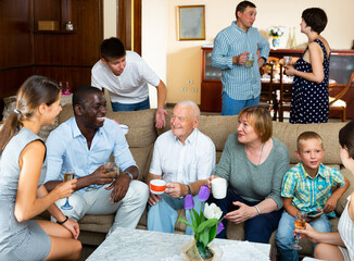 Big family with grandparents spending time together in living room