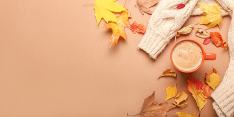 Autumn composition with cup of coffee, sweater and leaves on color background