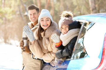 Happy family with car in forest on winter day