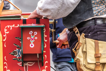 A showman playing a street organ outdoors