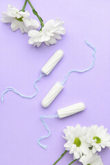 Obraz na płótnie Canvas Menstrual tampons and flowers on color background